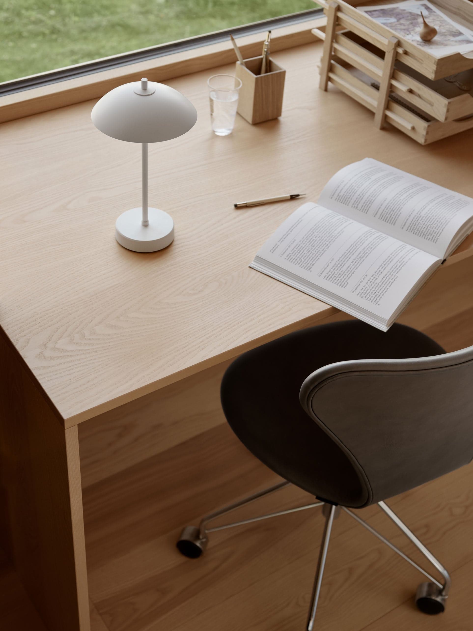 A warm desk scene with a portable lamp